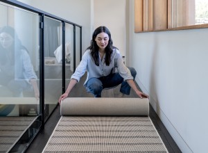 Woman unrolling rug runner upstairs