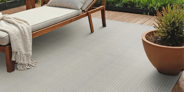 Custom outdoor rug on a deck next to a lounge chair 
